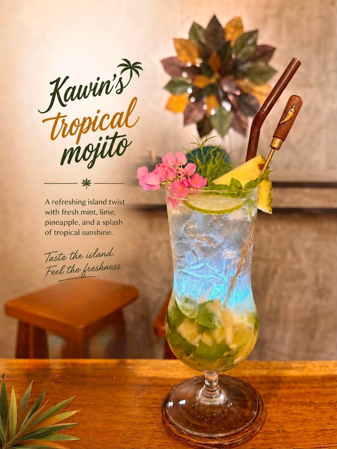 Kavins Tropical Mojito cocktail with blue layered drink, lime slices, pink flowers, and decorative straws on wooden table